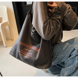 Détail d'un grand sac fourre-tout en toile gris foncé avec impression orange vif