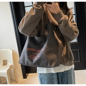 Selfie miroir montrant le grand sac fourre-tout en toile gris foncé porté à l'épaule