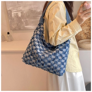 Lifestyle shot of large denim checkerboard tote bag with raw frayed edges and wide strap