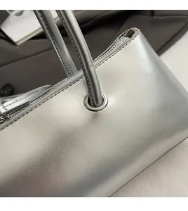 Detail of silver metallic textured faux leather bag with high-quality zipper and metal eyelets