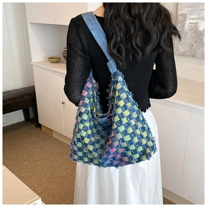 Detail of checkered denim tote bag with colorful patchwork and frayed fringe edges