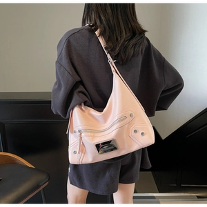 Detail view of pink leather tote bag featuring silver rivets and metal logo plate