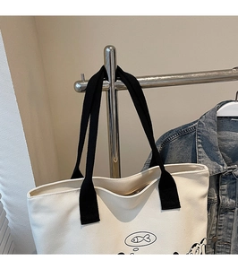 Détail du sac fourre-tout en toile crème avec motif de poisson mignon et anses noires