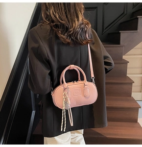 Vue détaillée d'un mini sac bowling rose clair avec relief et fermeture éclair en métal