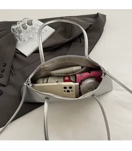 Silver metallic shoulder bag showing spacious interior compartment and smooth zipper detail