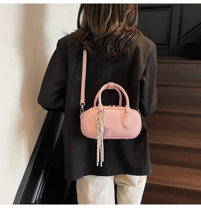 Détail du sac bowling rose avec logo embossé et breloque décorative en forme de raquette