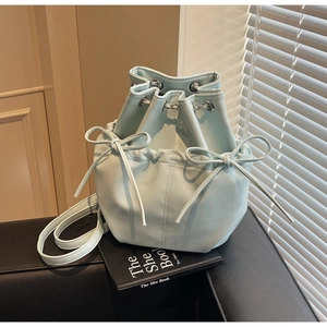 Detail of light blue bucket backpack with drawstring bow knots and metal eyelets