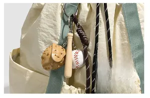 Dettaglio del ciondolo da baseball con guanto e mazza sullo zaino in nylon con lacci