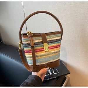 Detail der bunten gewebten Beuteltasche mit braunem Lederbesatz und goldener Schnalle