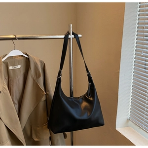 Close-up of black PU leather hobo bag with adjustable silver buckle and wide strap