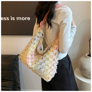 Detail of colorful woven tote bag with fringe edge and pink knotted wide shoulder strap