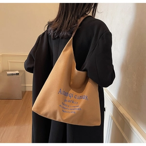 Photo lifestyle d'un grand sac cabas en toile kaki avec typographie bleue en salle