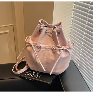 Detail of pink drawstring bucket bag featuring soft leather and bow-knot decorations