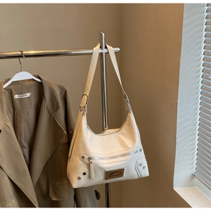 Close-up of cream white hobo tote bag with silver zippers and rivet hardware details