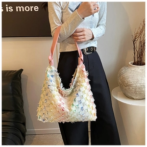Detail of multi-color woven denim tote bag with pink leather knotted shoulder strap