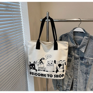 Détail du sac cabas en toile blanc cassé avec imprimés animaux sur un support métal
