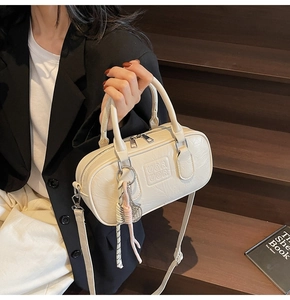 Sac bowling blanc crème en cuir texturé avec doubles poignées et pompon décoratif