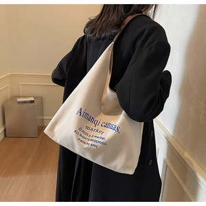 Sac fourre-tout en toile minimaliste avec lanières en cuir porté par un mannequin