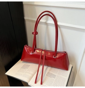 Detail of red patent leather shoulder bag with decorative long silver zippers