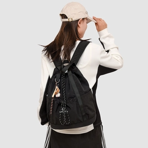 Vista posteriore di uno zaino nero leggero in nylon con coulisse e ciondolo sportivo