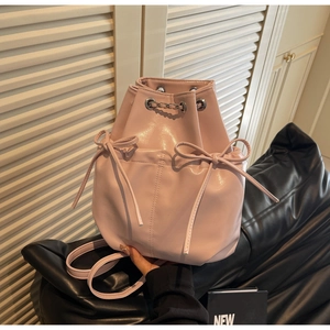 Detail of light pink bucket backpack with drawstring closure and bow decoration