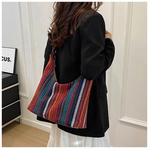 Primer plano del bolso tote tejido bohemio con rayas de colores y motivos étnicos