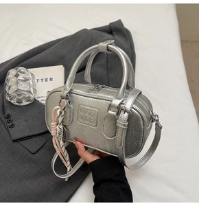 Sac bowling argenté métallisé avec logo UORUOR et détail de breloque tissée rose