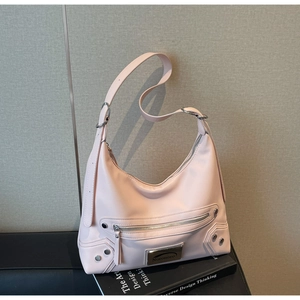 Detail of pink moto-style shoulder bag featuring metallic rivets and brand metal plaque