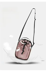 Detail van roze en bruine waterbestendige mini-crossbodytas met trekkoordsluiting