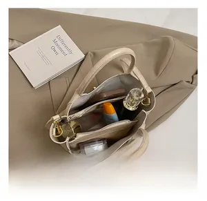 Vue intérieure du sac seau beige montrant les compartiments et la texture souple
