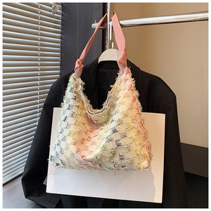 Detail of colorful rainbow plaid tote bag with frayed fringe and pink knotted handle