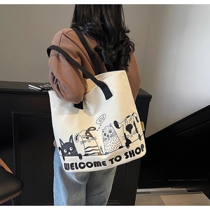 Détail d'un grand sac cabas en toile blanche avec anses noires et illustration de chat