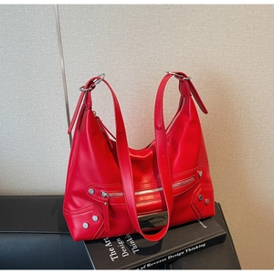 Detail of red motorcycle style hobo bag with silver zippers and stud embellishments