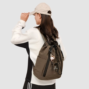 Vista laterale dello zaino in nylon marrone scuro con coulisse e ciondolo da baseball