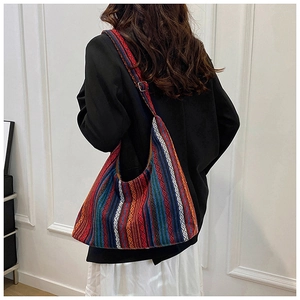 Detalle del bolso tote con rayas geométricas de colores y correa ajustable de estilo étnico
