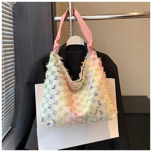 Close-up of rainbow tweed tote bag with pink strap knot detail and trendy fringe edges