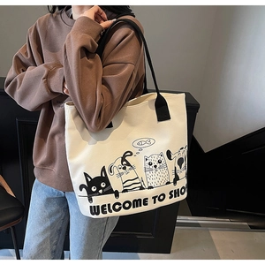 Gros plan d'un grand sac cabas en toile beige avec imprimés d'animaux mignons et anses noires