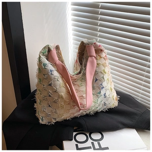 Detail of multi-color tweed tote bag with fringe edges and pink fabric top handles