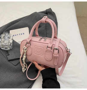 Vue détaillée du sac Boston rose en cuir texturé avec embossage des lettres UOR UOR