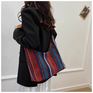 Primer plano de bolso tote bohemio con rayas de arcoíris y diseño étnico tejido
