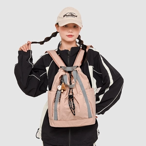 Dettaglio dello zaino con coulisse in nylon rosa chiaro con tasche laterali e cinghie