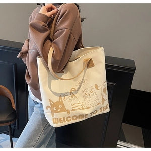 Détail du sac cabas en toile avec imprimé cartoon et bandoulières marron robustes