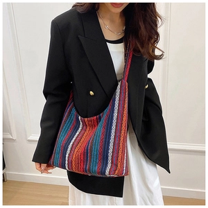 Detalle de bolso tote étnico con rayas de colores llevado por una modelo en estudio