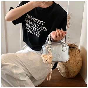 Silver metallic pillow bag with embossed text and a cute teddy bear charm detail