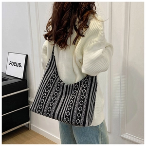 Primer plano detallado del gran bolso tote con diseño étnico blanco y negro en una modelo