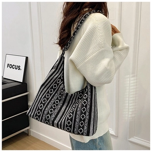 Detalle del bolso tote tejido con patrones geométricos en blanco y negro y textura de punto