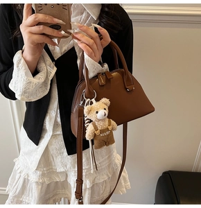 Deep brown crossbody bag featuring a cute plush bear pendant and polished faux leather