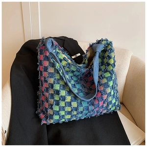 Detailed shot of multi-color checkerboard denim tote with trendy frayed edges and blue straps
