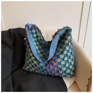 Close-up of colorful checkerboard weave texture and denim strap on a tote bag