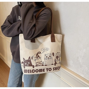 Détail du sac cabas en toile avec d'adorables motifs de chats et chiens et anses tissées